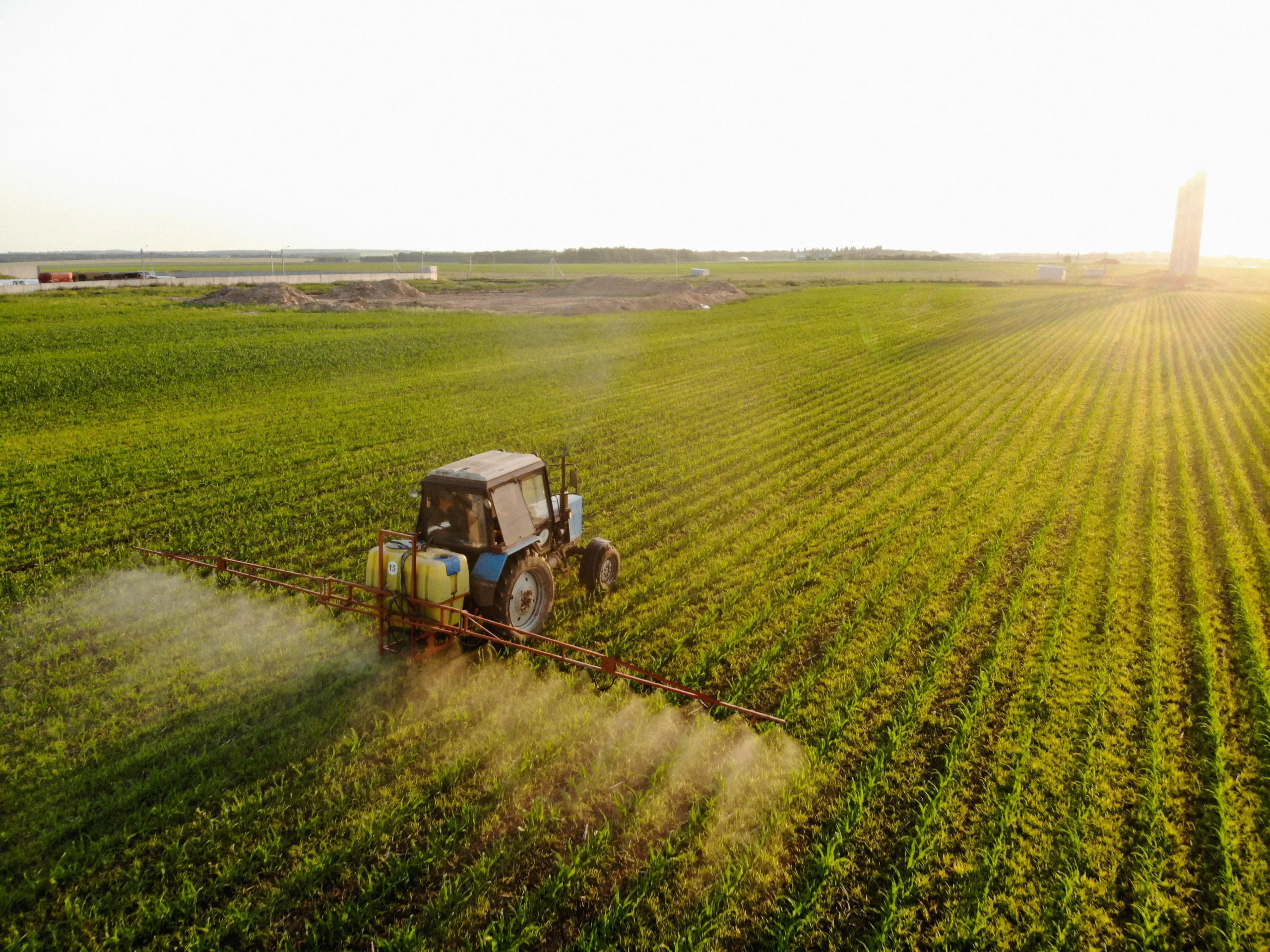tractor-sprays-pesticides-corn-fields-sunset